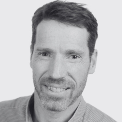 A headshot of Dr. Peter Owens, in black and white